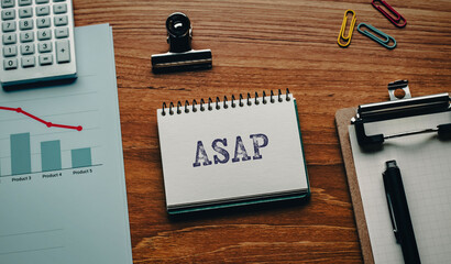 There is notebook with the word ASAP. It is an abbreviation for As soon as possible as eye-catching image.