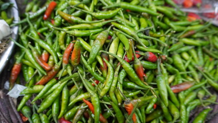 Pile of green chilies with a few red ones