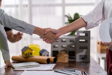 Architects shaking hands after closing a deal for building project