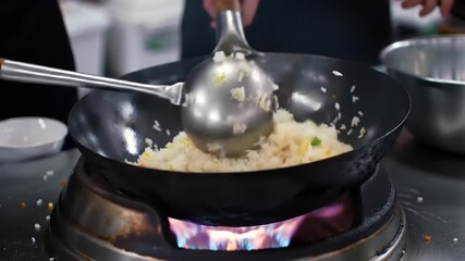Chef cooking fried rice with wok flame.