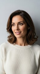 Fototapeta premium Confident Woman Wearing White Sweater Smiling in Studio Portrait
