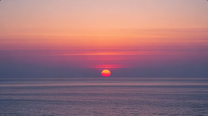Obraz premium Serene and Beautiful Healing Seascape with a Red Sun Setting on the Horizon