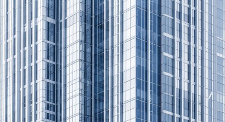 Obraz premium Modern glass skyscraper facade with repeating vertical lines and reflections