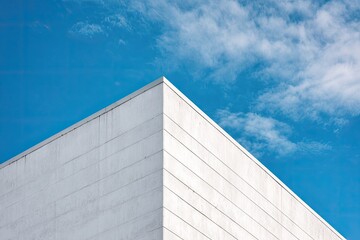 Architectural corner of a white building against a bright blue sky