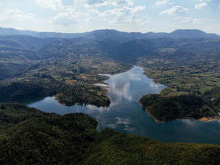 Aerial view of Rovni Lake reservoir and surrounding hilly landscape in Serbia. g.