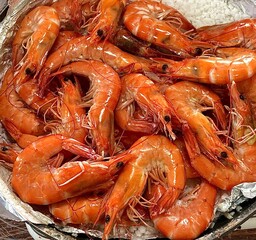 Golden fried shrimp with crispy, textured coating, tender meat inside, and a rich orange-golden color, captured in close-up to highlight its crunchy surface and appetizing appearance