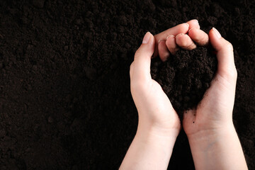 Woman with pile of fresh soil, top view