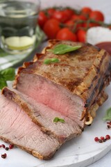 Delicious baked beef meat, spices and tomatoes on table, closeup
