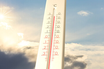 Extremely high temperature on thermometer against blue sky on sunny day. Summer weather