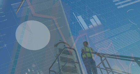 Technician wearing safety vest and helmet climbing ladder on tower at wind farm, with data charts