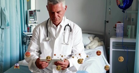 Reviewing medical records doctor consulting tablet in hospital room, with stethoscope and plush toy
