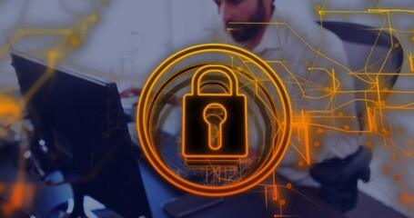 Displaying orange padlock icon over office worker with headphones at desk with circuit overlay