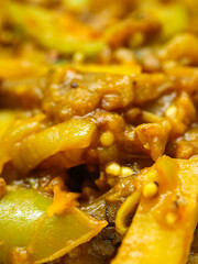 An extreme close up macro photograph of a savory vegetable stew showing the detail and texture of the cooked ingredients and spices in the rich gravy
