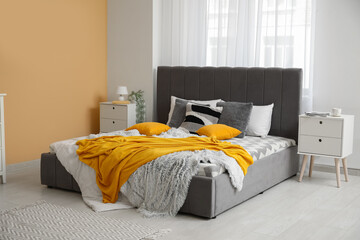 Stylish bedroom with bed, bedside tables and blanket