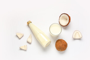 Bottle and glass with coconut milk on white background