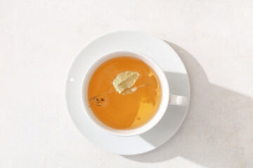 Cup of tasty linden tea on white background