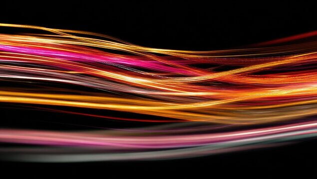 Abstract, vibrant light trails flowing across a black background