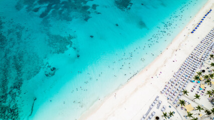 Stunning aerial view of turquoise Caribbean waters meeting pristine white sandy beach in the Bahamas, showcasing the beauty of luxury tropical travel and paradise vacation destination.