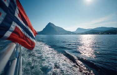 Norwegian flag waving over a fjord