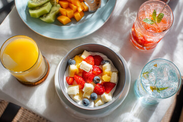 Delightful fresh fruit breakfast spread with refreshing beverages enjoyed in a sunlit outdoor setting
