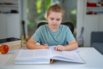 Kid reading book at home. Kid studying with books in playroom. Teen reading story book in children room. Kid learning with book. Smart student doing homework with book in cozy interior.