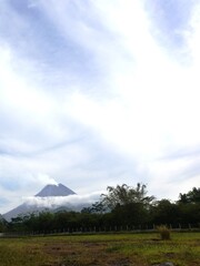 Obraz premium Beautiful view of the still active mount Merapi at Yogyakarta, Indonesia in the morning with white clouds surrounding it