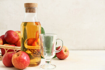 Bottle of fresh apple cider and wicker basket with fruits on white background