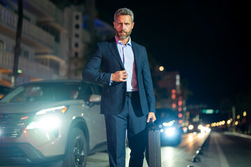 Business man with briefcase in suit walking at night city. Rich man in a suit outdoor. Business man...