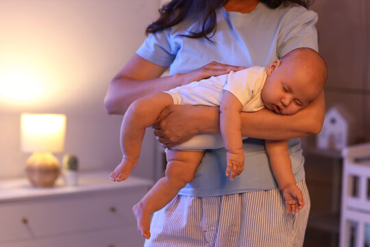 Young mother with her cute little sleeping baby at night in bedroom, closeup - Powered by Adobe