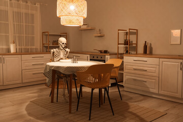 Human skeleton model with fork near dining table in kitchen at night