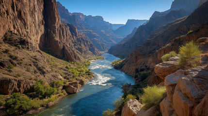 Majestic Canyon River: A breathtaking view of a grand canyon with a winding river, under a clear blue sky, evoking a sense of vastness and natural beauty.