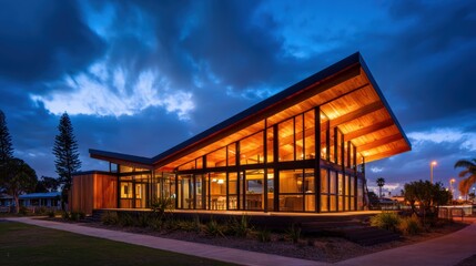 Obraz premium Modern architectural design of a house illuminated at dusk with dramatic cloud formations in the background