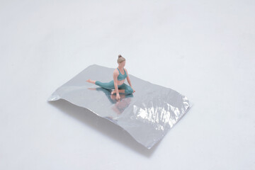 Miniature Figure Practicing Yoga on Metallic Surface in a Studio Setup