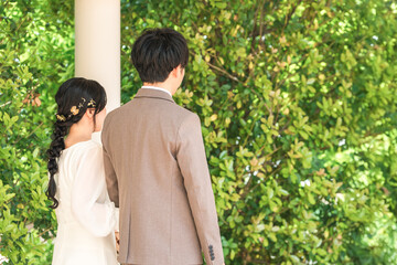 結婚式場を歩く新郎新婦の後ろ姿（入場・結婚式・アジア人）

