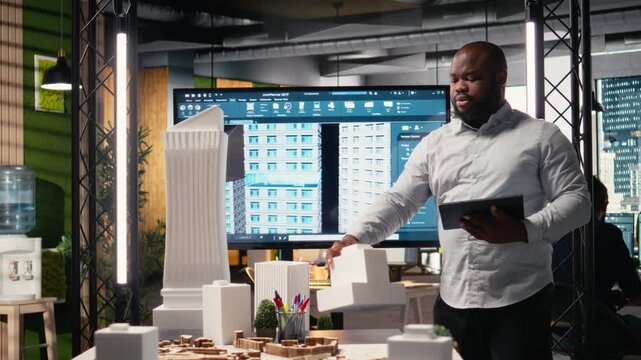 Property investment developer checks blueprints and layout plans, reviewing construction site in a modern office. Analyzing zoning regulations for a residential development project. Camera A.