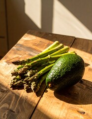 Fresh asparagus and avocado on a wooden table