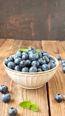 Fresh blueberries in bowl on wooden table