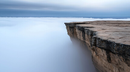 Fototapeta premium Breathtaking Landscape of a Rocky Edge Overlooking a Sea of Clouds with Soft Light and Tranquil Atmosphere at Dawn in the Mountains
