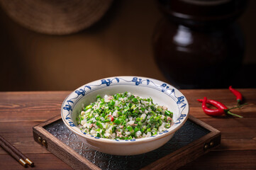 Stir-fried radish, green vegetables and minced meat, old kitchen interior wooden table background