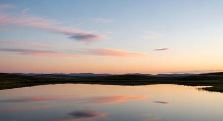 Obraz premium A tranquil lake perfectly reflects the soft pastel colors of a beautiful sunset sky over distant mountains