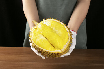 Fresh Durian Fruit with Golden Flesh and Spiky Shell on Wooden Table