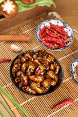 Fried Silkworm Pupae and Chili Peppers - Traditional Asian Street Food on Bamboo Mat