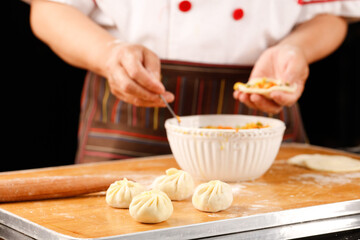 Freshly Made Xiaolongbao Dumplings Being Prepared by Chef with Rolling Pin and Flour on Wooden Board