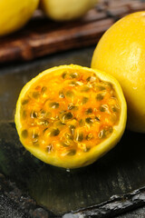 Freshly cut passion fruit showing golden pulp and seeds on slate surface