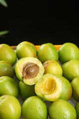 Fresh Xinjiang Green Apricots Cut Open Showing Golden Flesh and Pit
