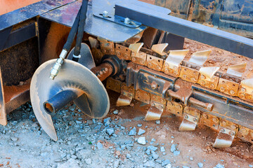 Close up of ground excavation tool on heavy machinery, highlighting its metal blades
