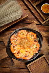 Garlic Shrimp with Glass Noodles in Cast Iron Pan on Wooden Table - Asian Seafood Dish