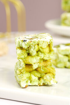 Green matcha sachima specialty snack bars covered with nuts - traditional Chinese confectionery dessert