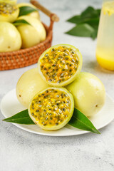 Fresh Golden Passion Fruit Halves with Pulp and Seeds on White Plate