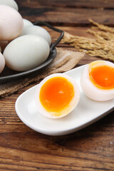 Fresh Duck Eggs with Orange Yolks on Rustic Wooden Table with Wheat Stalks